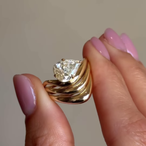 Sculptural Gold-Toned Ring with Wavy Design and Pear-Shaped Clear Gemstone