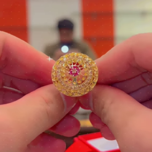 Ornate Gold-Toned Ring with Red Gemstone Center and Circular Filigree Design